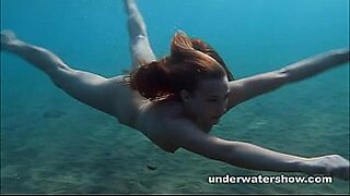 female in thong swimming underwater